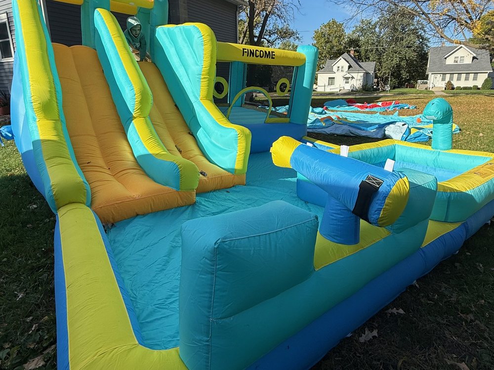 Inflatable double water slide landing in a splash pool