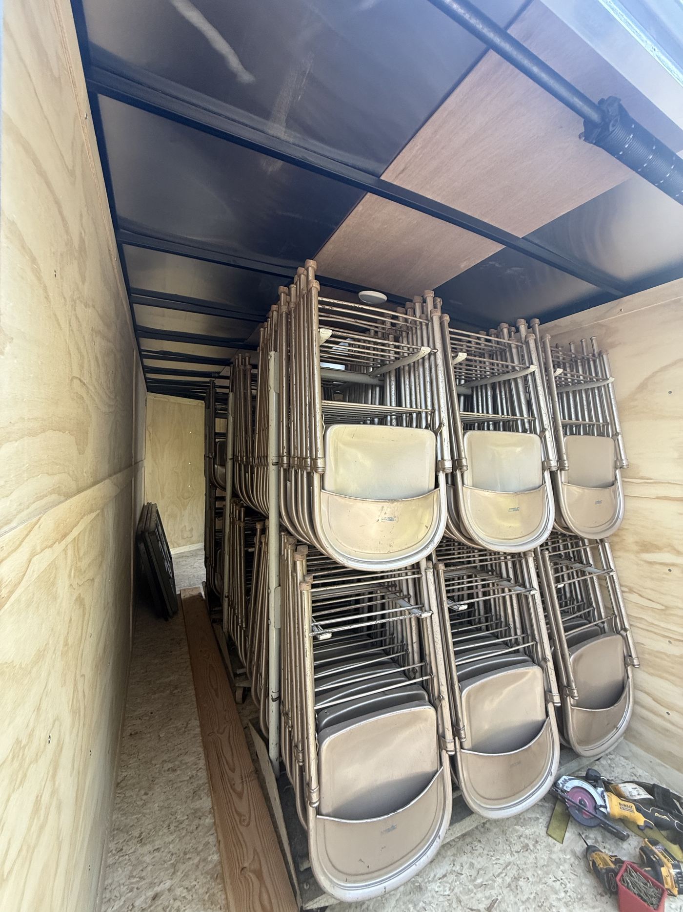 Rows of folding chairs on racks inside the trailer